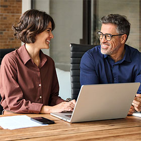 A woman and man sitting at a table in discussion