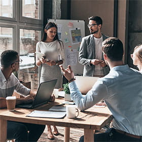 Group of five people gathered around a table in a discussion