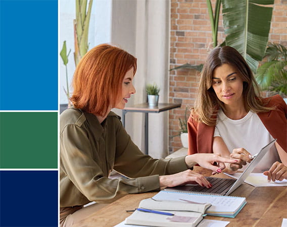 Two women sitting a desk reviewing paperwork