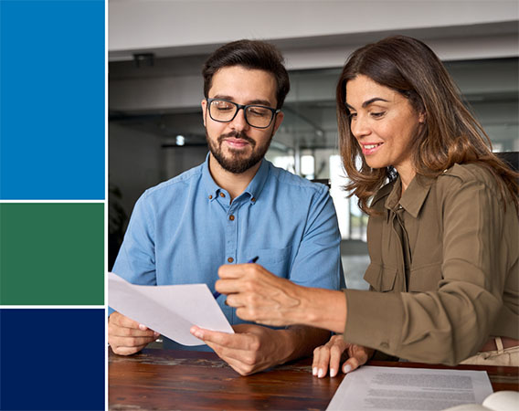 Man and Woman sitting at table going over a document on paper