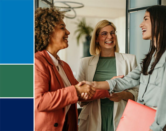 Group of three women, two of which are shaking hands