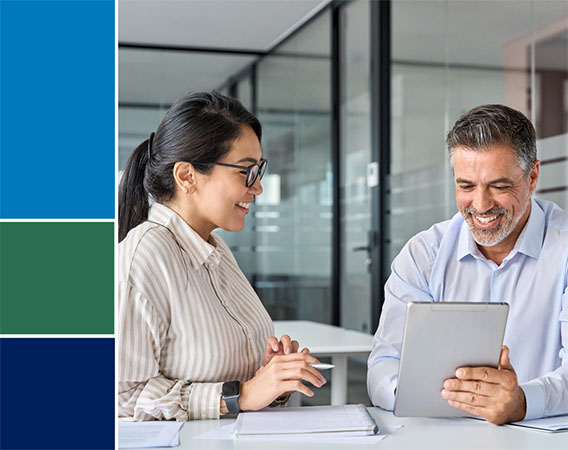 Woman and Man sitting at table, smiling, reviewing documents