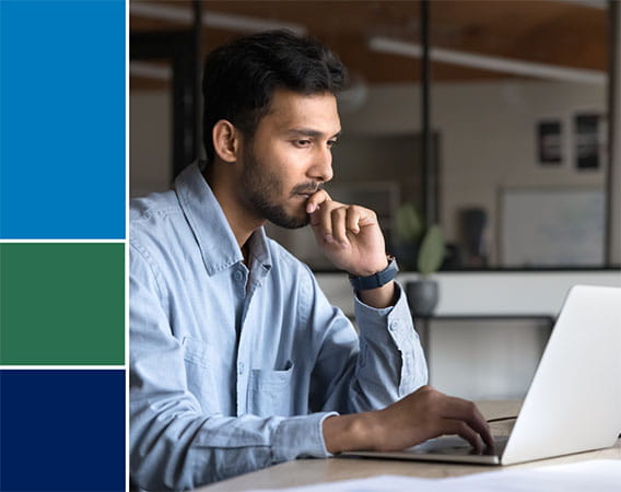 Man sitting at desk working on laptop