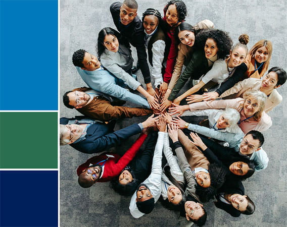 Group of people looking up into the sky, hands on top of each other