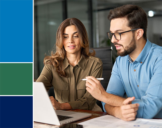 Woman and Man sitting a table looking at a laptop together
