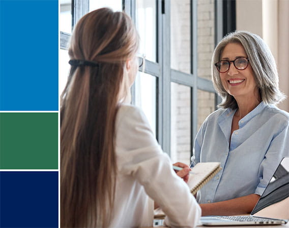 Two women talking to each other at a counter, older woman facing camera
